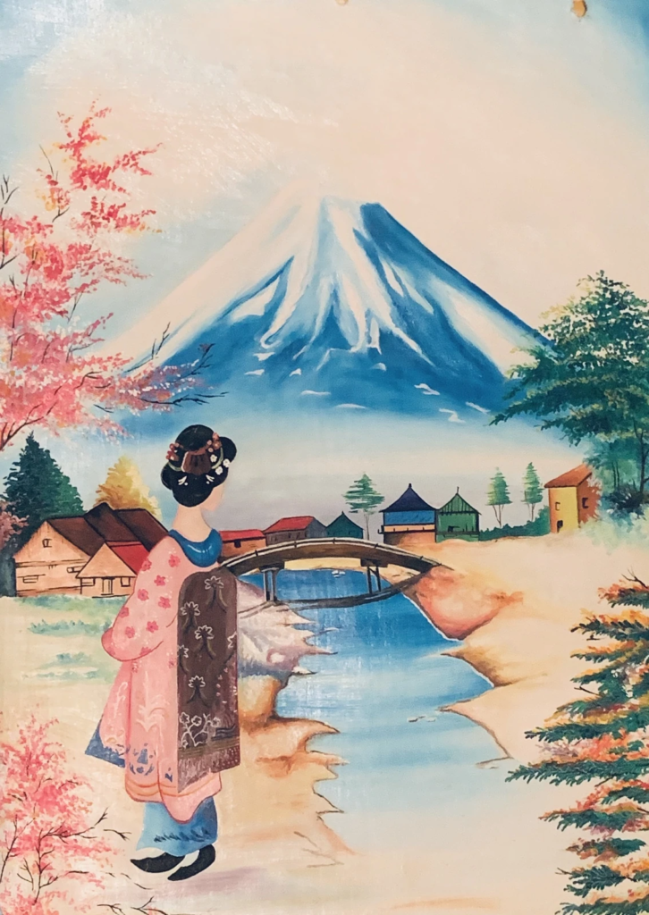 A figure in a pink kimono beside a river and bridge, with a snow-capped mountain and flowering trees beyond.